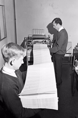 Computer printed cheques. After the cheques were printed at the Bureau of Statistics they were returned to the ATO to be fed through another machine that counted and prepared them for postage. Paul Gleeson holds the pile of cheques and John Gay watches as they are processed. (The Sydney Morning Herald).