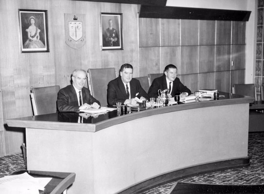 Commissioner Cain (centre), with Second Commissioner JM Belcher (left) and First Assistant Commissioner V Grant (right) seated on their raised dais at the 1966 Deputy Commissioners conference.